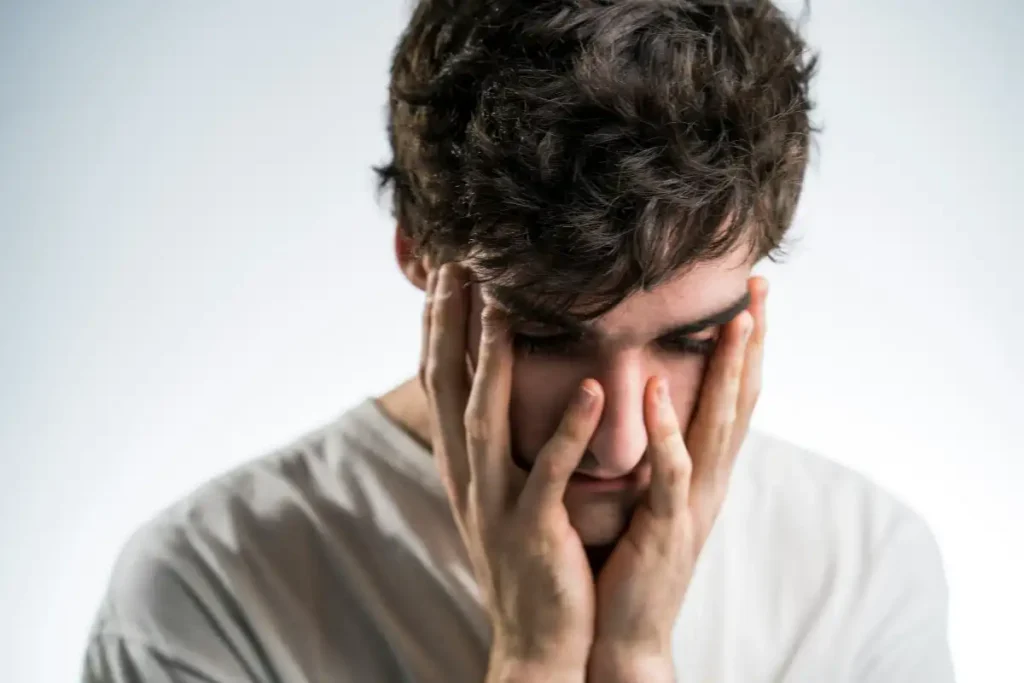 A man holds his head in his hands, conveying feelings of frustration or overwhelming emotion